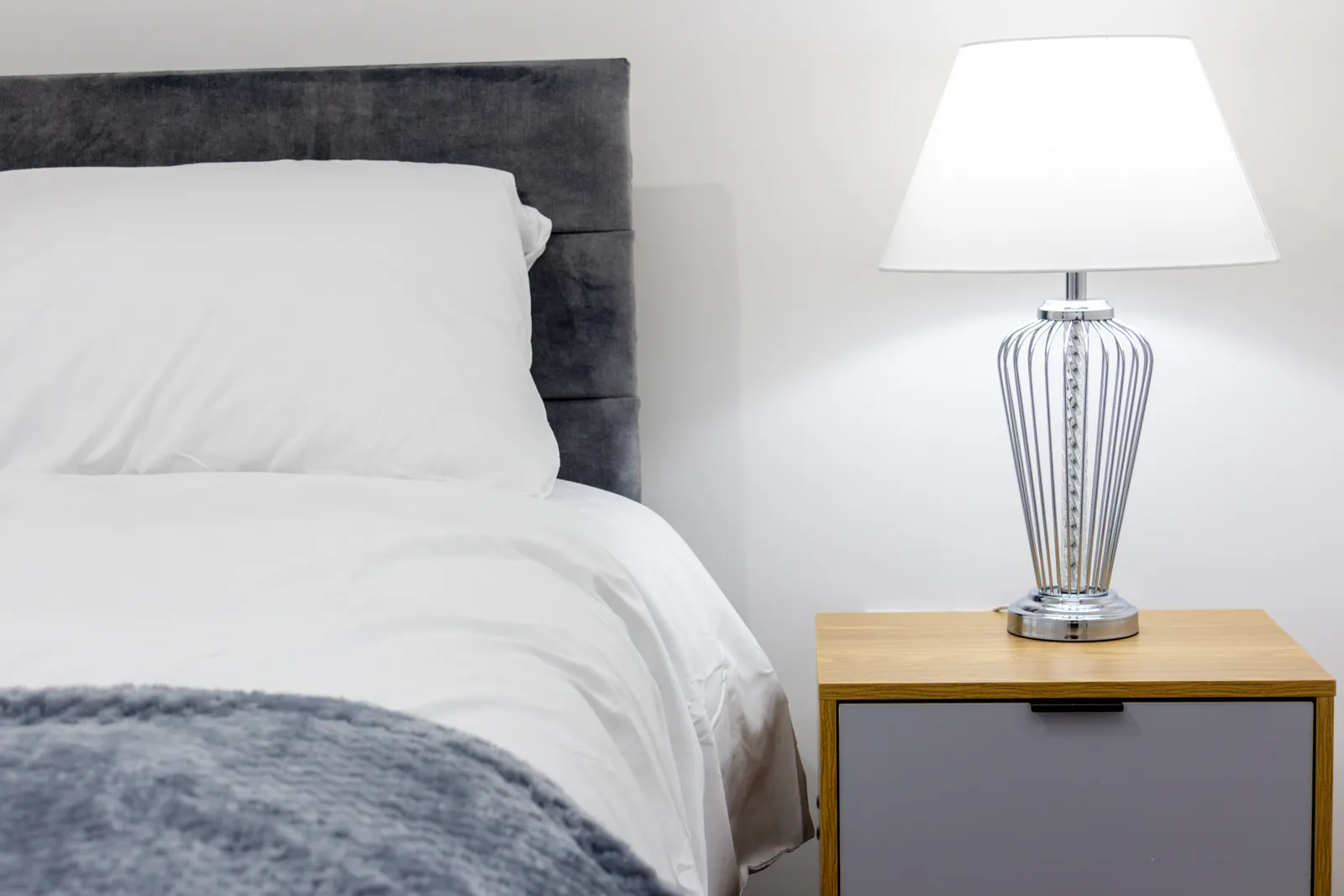 The Dudley Lounge — a bedroom with a double bed and table lamp