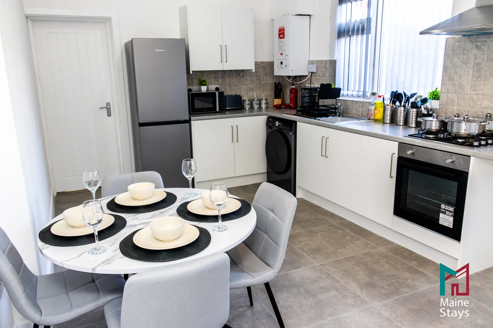 The Dudley Lounge — Kitchen with a round dining table set for four