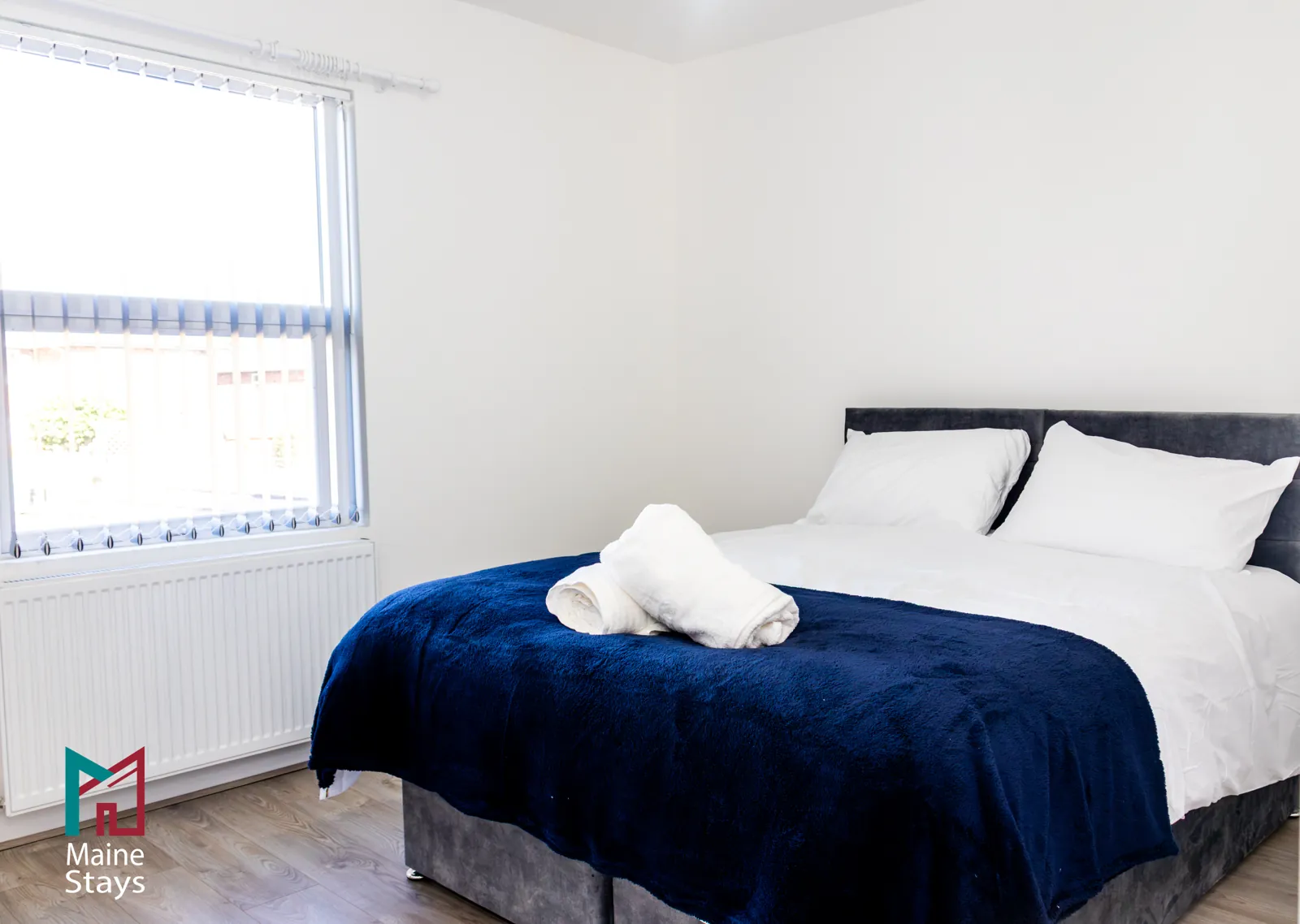 The Dudley Lounge — Bedroom with a double bed and navy throw