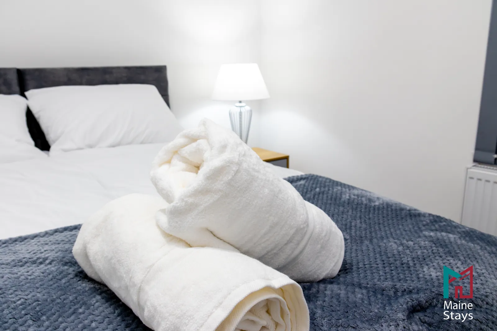 The Dudley Lounge — Fresh rolled towels on a grey throw