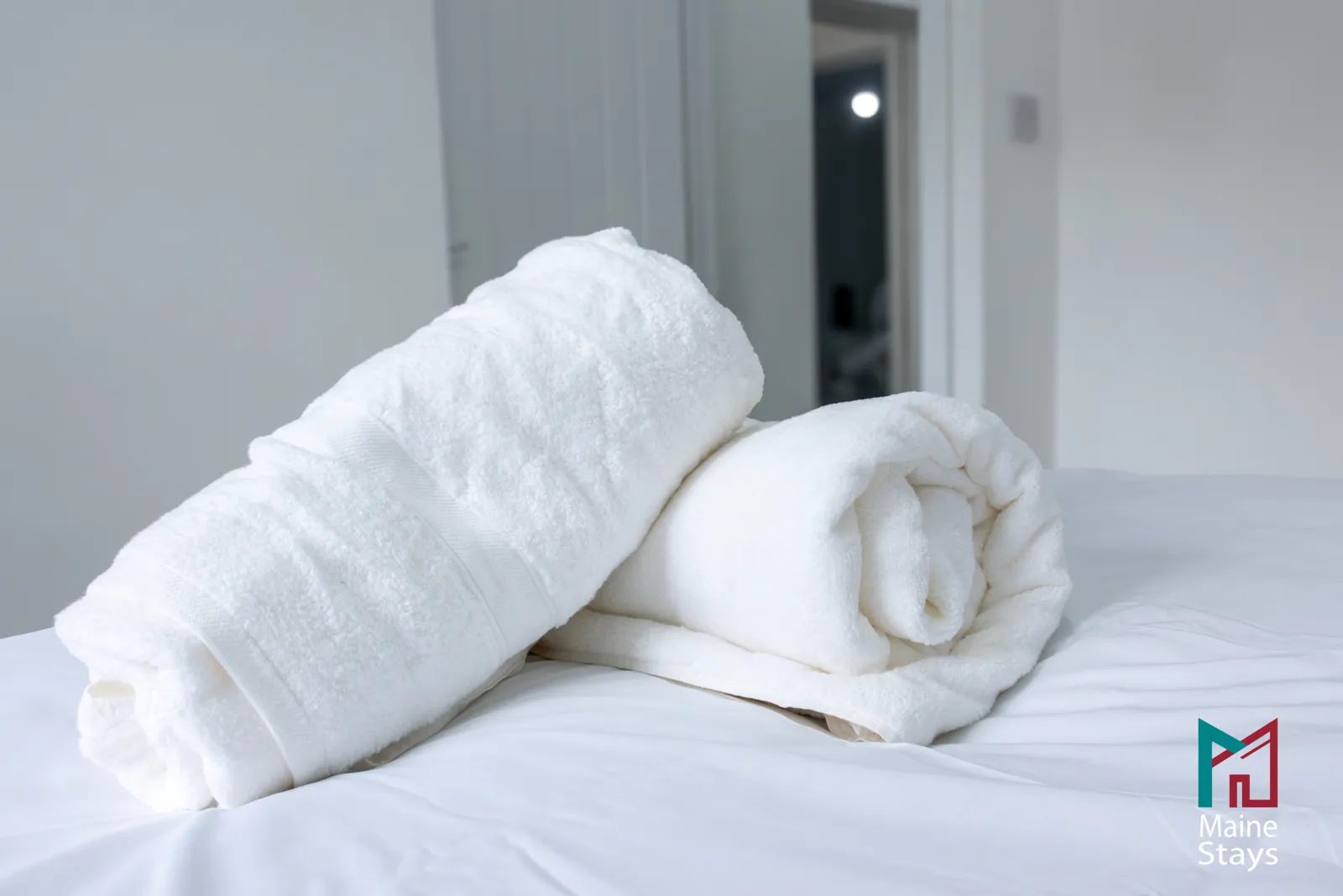 The Dudley Lounge — Rolled towels on a made bed