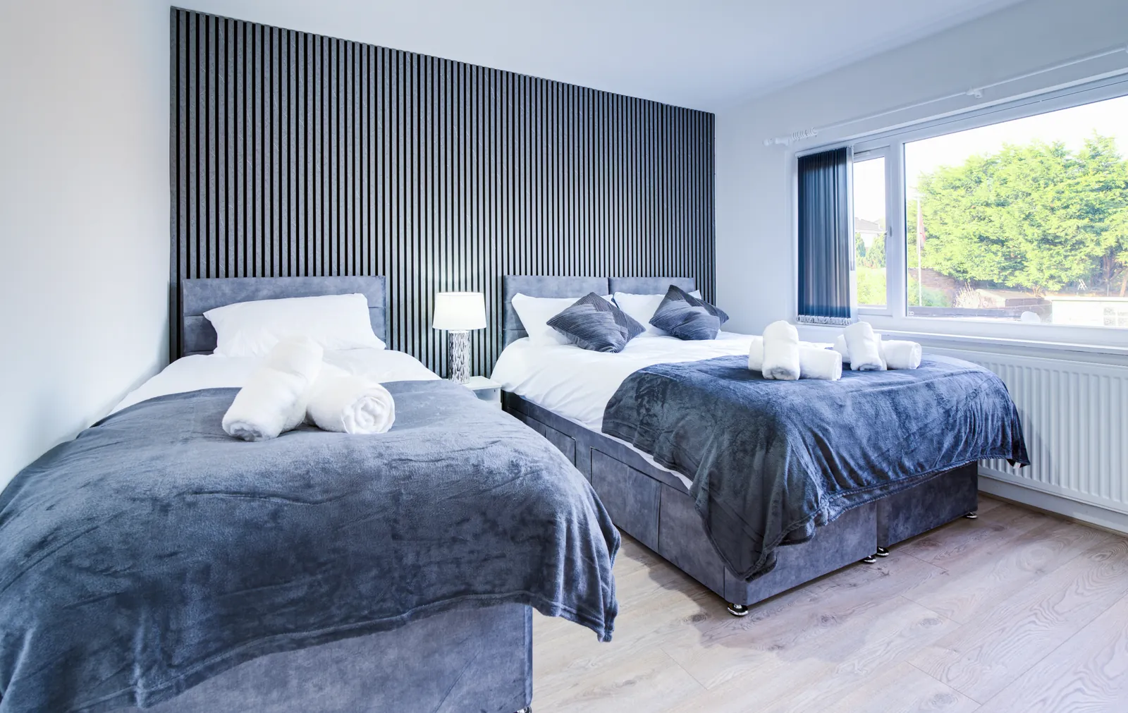 The Merry Hill Lounge: bedroom with a double bed and a single bed beside a wide window