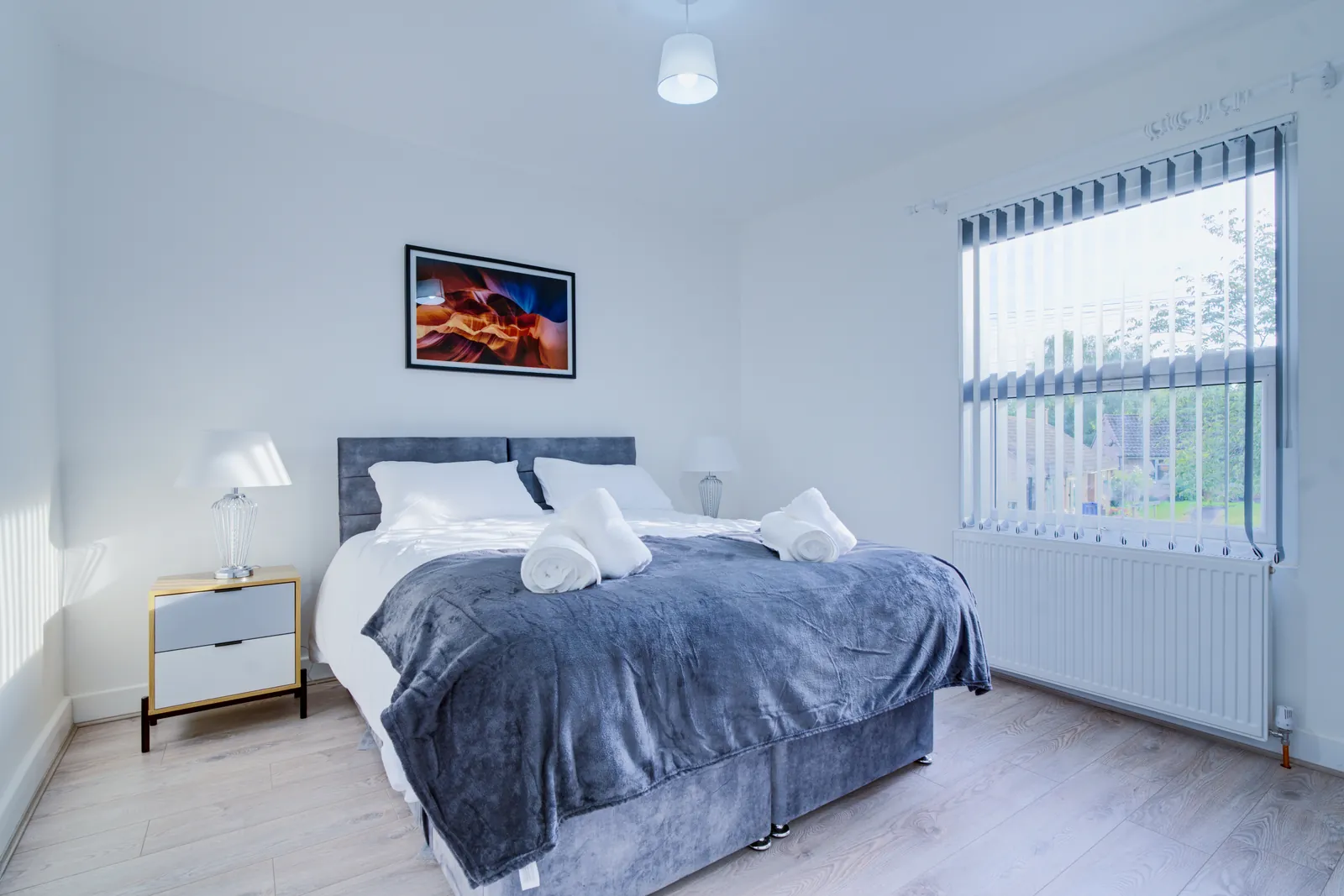 The Merry Hill Lounge: double bedroom with two bedside lamps and framed art