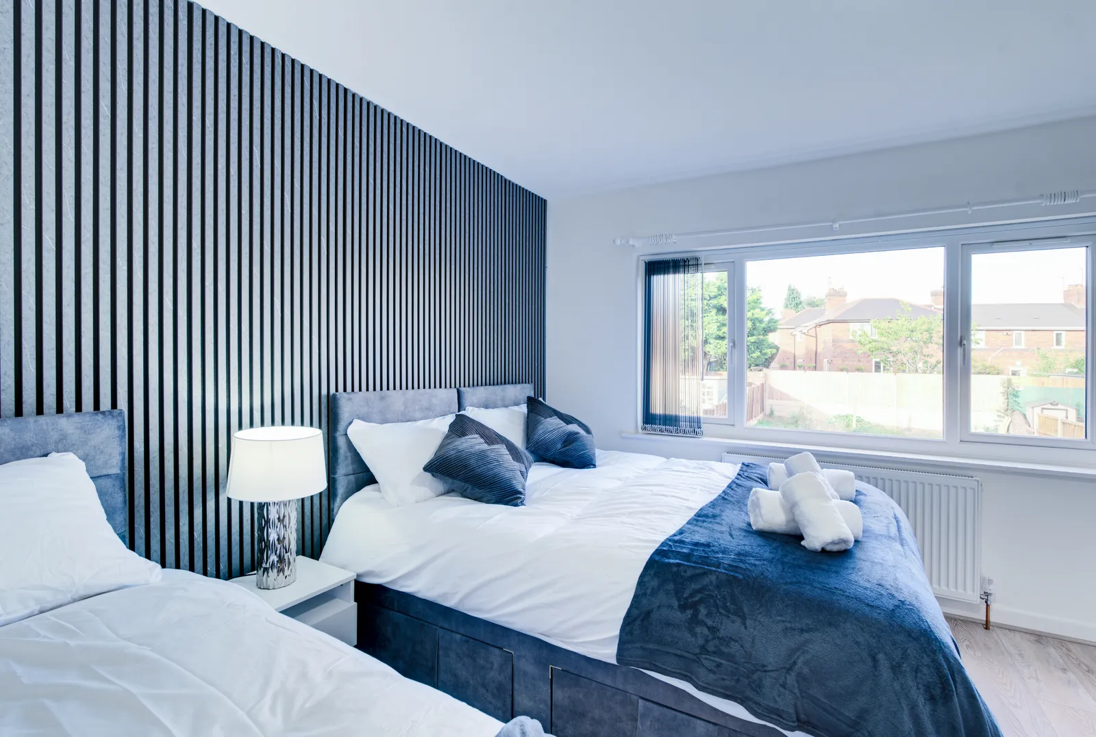 The Merry Hill Lounge: double bed with a table lamp and a wide window